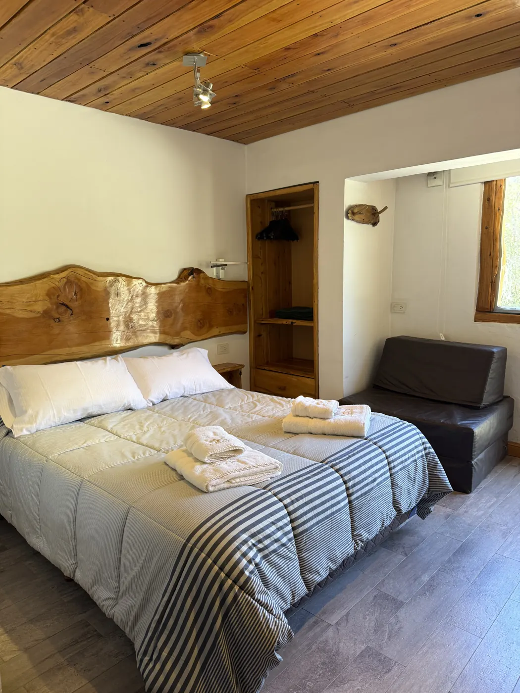 Cama con cabecera de madera en la cabaña Amulen