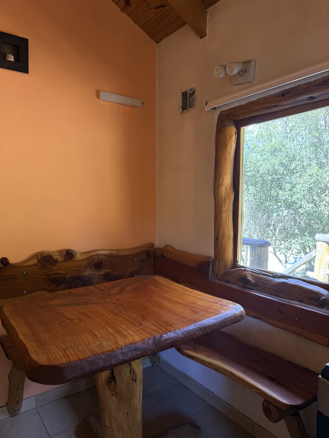 Rincón comedor de madera junto a la ventana en Quimey